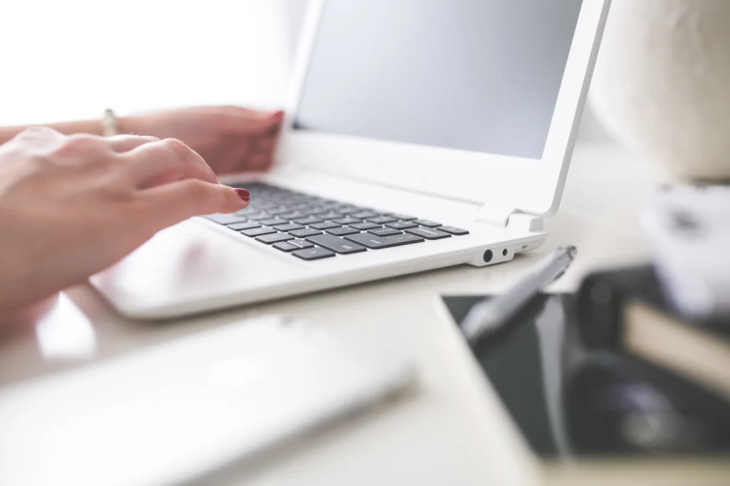 Mains tapant sur un clavier d'ordinateur portable